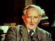 Tolkien in zijn studeerkamer, misschien wel met het inmiddels beroemde
manuscript ergens tussen de stapels